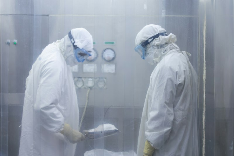 Workers in protective suits handling chemicals safely
