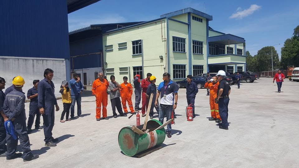 James Issachar demonstrating fire extinguisher use during on-site safety training