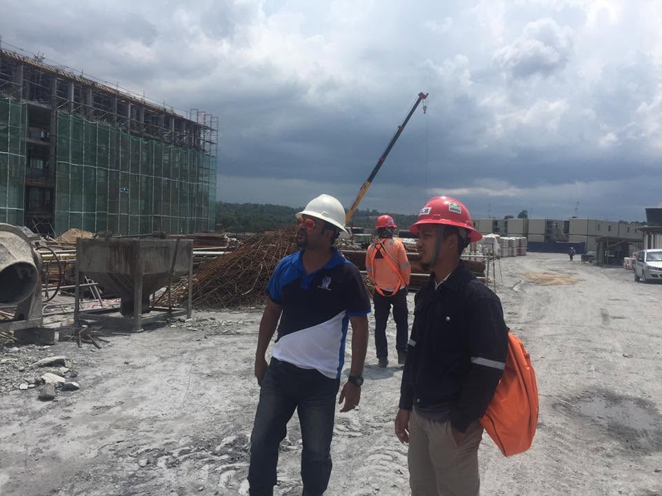 James Issachar on a construction site wearing a hard hat and safety vest